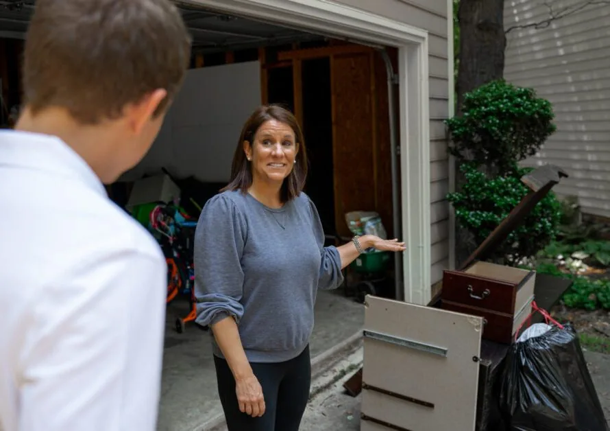 Happy customer showing a junk removal professional garage junk that needs to be removed